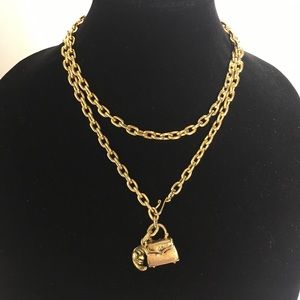 Gold tone chain necklace with moon and purse charm